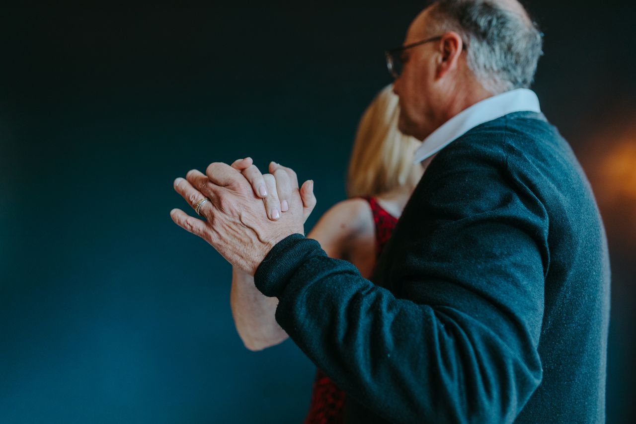 A senior couple gracefully dancing indoors, showcasing love and connection.